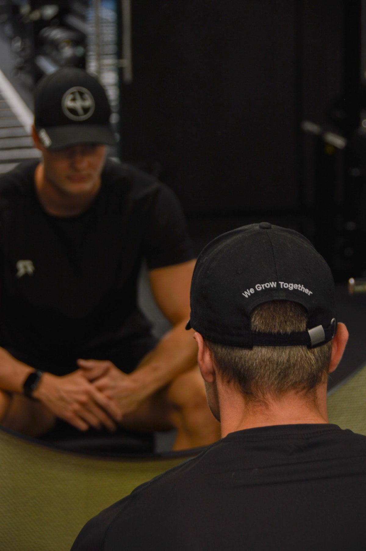 Twee sporters in gesprek na een set, pet met We Grow Together