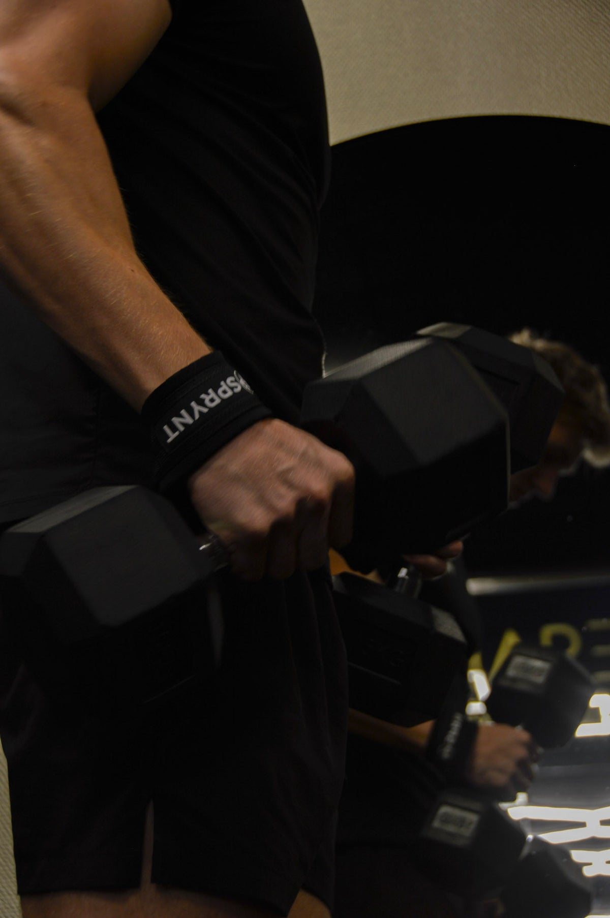 Sporter traint met een dumbbell en SPRYNT strap om de pols